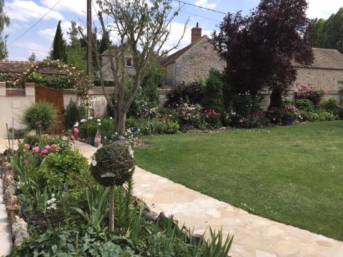 a garden with a lawn and flowers in a yard at Les Prémices De La Forêt in Chailly-en-Bière