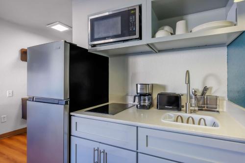 a kitchen with a sink and a refrigerator at Studio 6 Seattle, WA Sea Tac Airport South in SeaTac