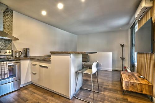 a kitchen with white cabinets and a wooden table at Downtown Sherby - Central, Parking, King Bed, Sleeps 3 in Sherbrooke