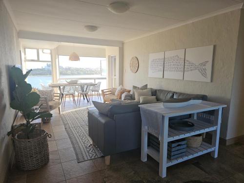 a living room with a blue couch and a table at Be Lazy with a Sea View in Jeffreys Bay
