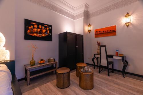 a room with a bed and a table and chairs at Riad L'ECOLE in Marrakech
