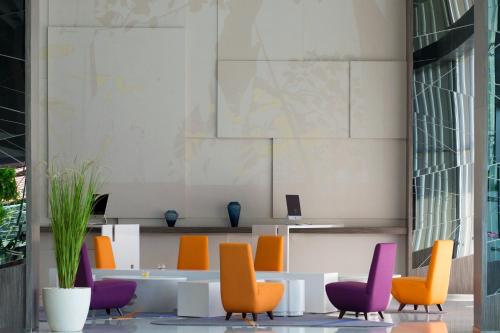 a lobby with colorful chairs and a table at Novotel Makassar Grand Shayla in Makassar