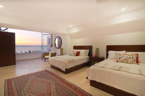a bedroom with two beds and a view of the ocean at Two-Story Beachfront Oasis in Puerto Vallarta