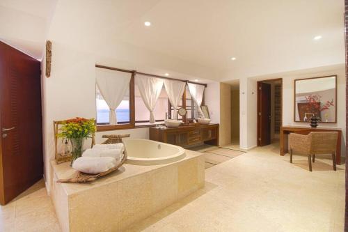 a large bathroom with a tub and a desk at Two-Story Beachfront Oasis in Puerto Vallarta