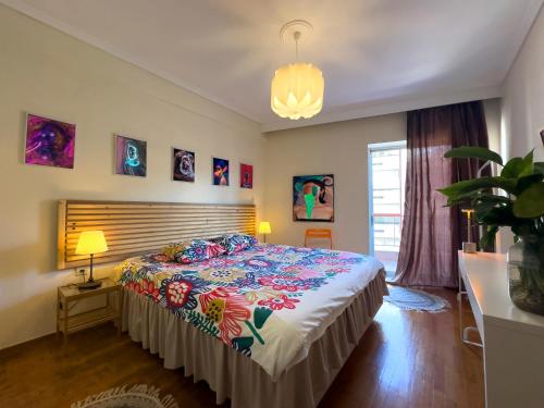 a bedroom with a bed with a colorful bedspread at Spacious Artistic Flat With Private Parking in Thessaloniki