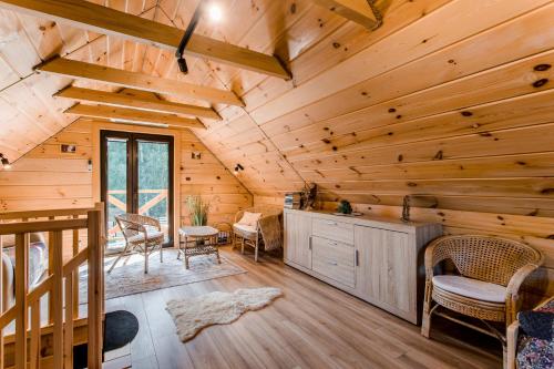 a log cabin living room with wooden ceilings at Leśny domek in Białowieża