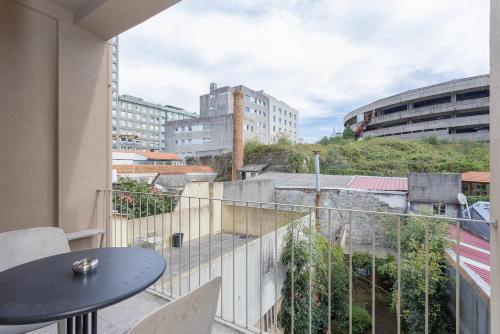 een balkon met een tafel en een aantal gebouwen bij Liiiving in Porto - Trindade Deluxe Studios in Porto