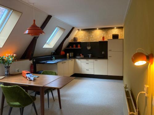 a kitchen with a wooden table and chairs in a room at Vintage appartement in Pakhuis Friesland in centrum in Leeuwarden