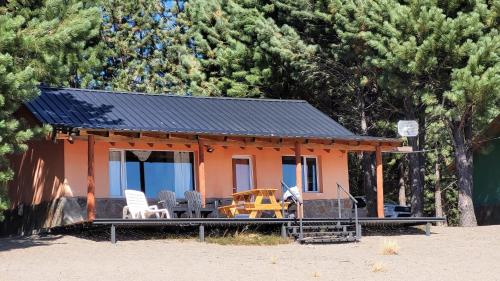 a small orange house with chairs and a table at Complejo Don Cirilo in Villa Pehuenia