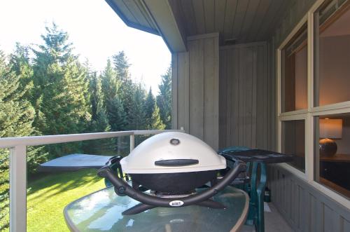 a grill sitting on a table on a balcony at Aspens on the Mountain Ski In Out in Whistler
