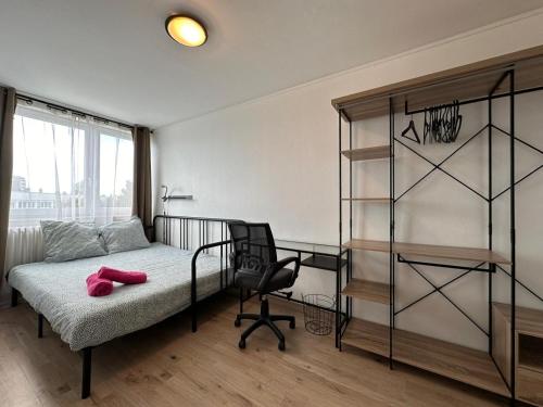 - une chambre avec un lit, une chaise et une étagère dans l'établissement Le Jules Verne, proche de la Gare, à Boulogne-sur-Mer