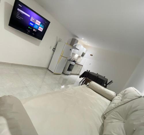 a white room with a bed and a tv on the wall at Estudio Alma in Miramar