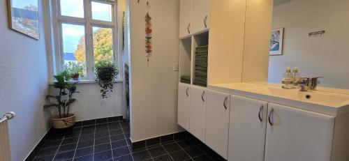 a bathroom with a sink and a mirror and a window at Townhouse in the Center Free Parking in Aalborg