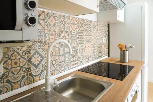 a kitchen with a sink and a tile wall at Apartamento frente al mar in Puertito de Güímar
