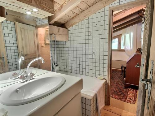 La salle de bains est pourvue d'un lavabo blanc et d'une baignoire. dans l'établissement Appartement de standing Mont d'Arbois, à Megève