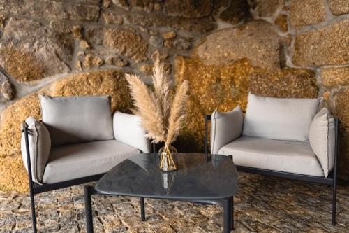 two chairs and a table in front of a stone wall at Refúgios da Natureza in Entre -os- Rios