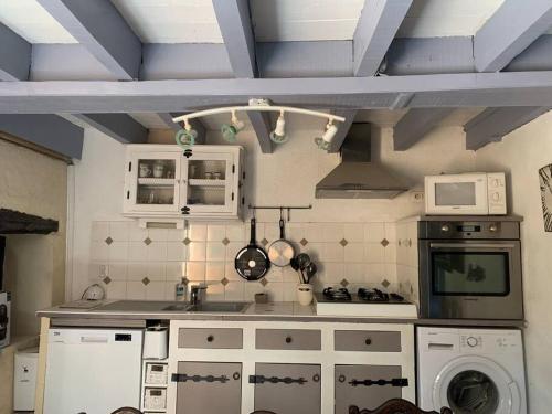 une cuisine avec un évier et une cuisinière four supérieur dans l'établissement La merveille d'Urval, à Urval