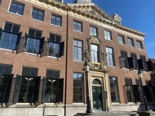 a red brick building with black shuttered windows at Vintage appartement in Pakhuis Friesland in centrum in Leeuwarden
