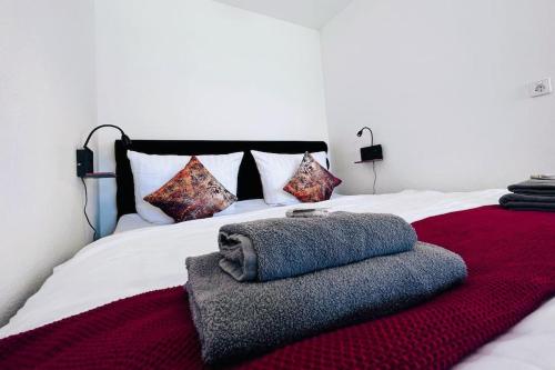 - un grand lit blanc avec une couverture rouge et des oreillers dans l'établissement Apartment mit Grünblick & Wintergarten im Schwarzwald, à Löffingen