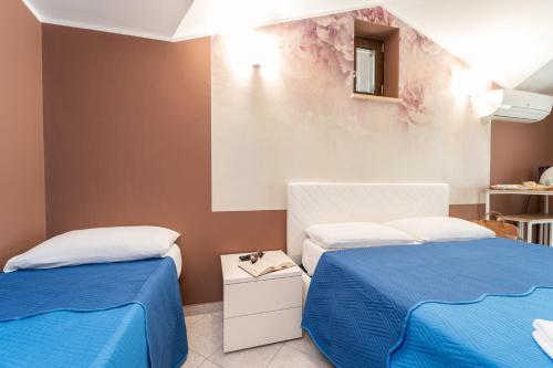 two beds in a room with blue and white at B&B Golden House & spa in Rose