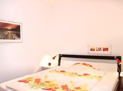 ヴァーネミュンデにあるFerienwohnung Warnemünde L (S2)のベッドルーム1室(壁に絵が描かれた白いベッド1台付)