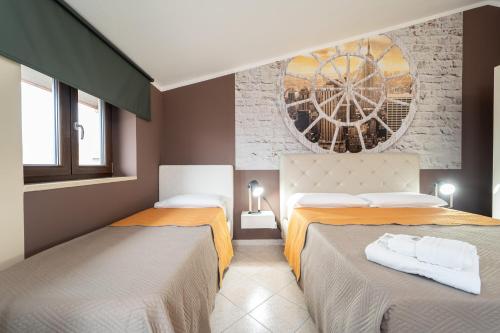 a bedroom with two beds and a painting on the wall at B&B Golden House & spa in Rose