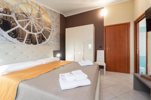 a bedroom with a bed with towels on it at B&B Golden House & spa in Rose