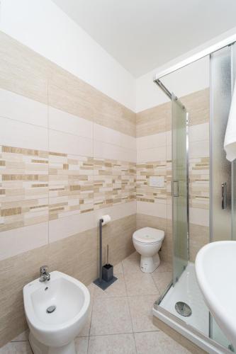 a bathroom with a toilet and a sink and a shower at B&B Golden House & spa in Rose