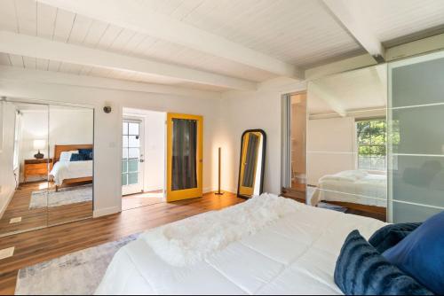 Un dormitorio con una gran cama blanca y un espejo. en Berkeley Heaven, en Berkeley