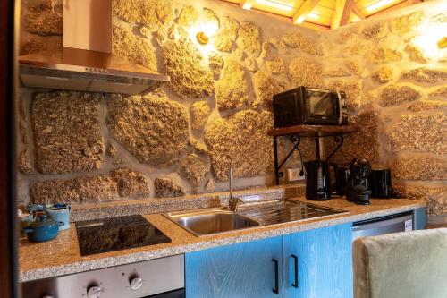 a kitchen with a sink and a tv on a wall at Refúgios da Natureza in Entre -os- Rios