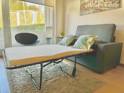 a bed in a living room with a couch at Apartamento en exclusivo barrio Lomas de san Andrés con estacionamiento in Concepción