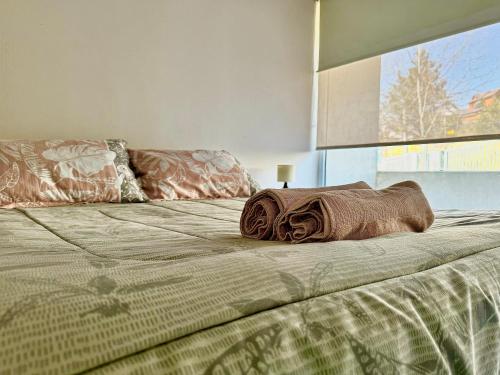 a bed with two pillows on top of it at Apartamento en exclusivo barrio Lomas de san Andrés con estacionamiento in Concepción