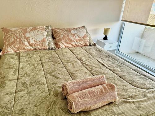 a bed with two pillows on it in a bedroom at Apartamento en exclusivo barrio Lomas de san Andrés con estacionamiento in Concepción