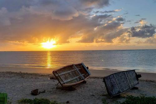 ein paar Boote, die bei Sonnenuntergang am Strand sitzen in der Unterkunft Villas Vovô Marcos - Beira Mar in São José da Coroa Grande