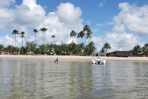 ein Boot im Wasser neben einem Strand in der Unterkunft Villas Vovô Marcos - Beira Mar in São José da Coroa Grande