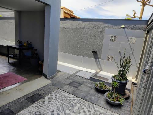 a patio with two potted plants and a wall at Bertholi Beira-Mar in Serra