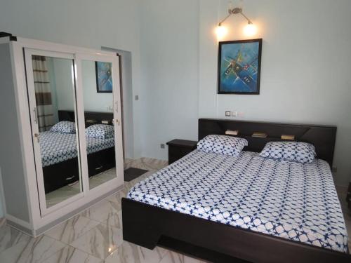 a bedroom with a bed and a large mirror at Appartement moderne avec balcon in Lomé