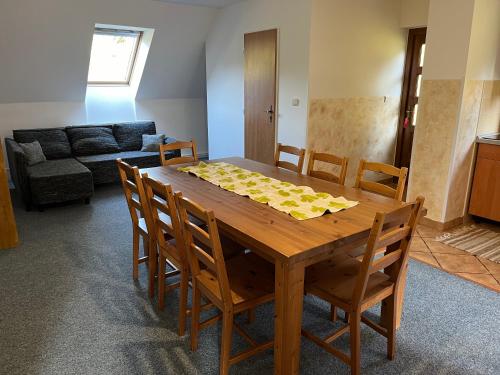 a dining room table with chairs and a couch at Ubytování Chotěvice in Hostinné