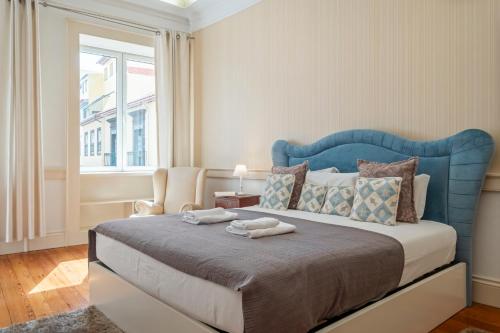 Bett mit blauem Kopfteil in einem Schlafzimmer in der Unterkunft Villa Diniz by Madeira Dream Stays in Funchal