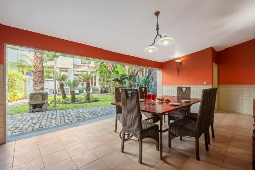 a dining room with a table and chairs and a fireplace at Villa Júlio Dinis by Madeira Dream Stays in Funchal