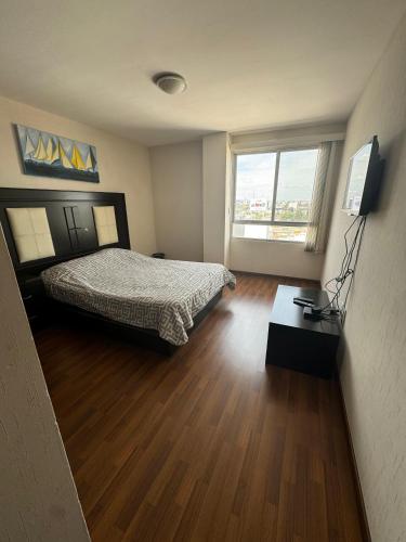 a bedroom with a bed and a television in it at Amplio departamento con balcon in San Luis Potosí