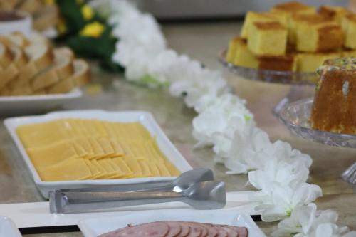 a table with a plate of cheese and other desserts at Eco Hotel in Navegantes