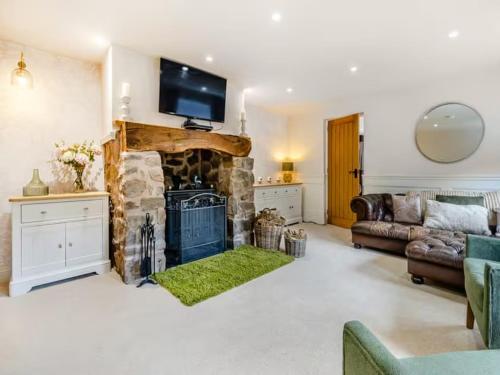 a living room with a stone fireplace with a tv on top at Private Lodge with Spa and Sauna in Shrewsbury
