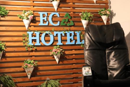 a wall with a hotel sign and potted plants at Eco Hotel in Navegantes