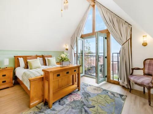 a bedroom with a bed and a balcony at Private lodge spa, sauna, hot tub, outdoor kitchen with firepit area in Shrewsbury