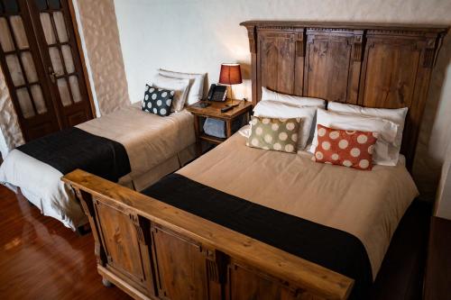 a bedroom with two beds and a lamp on a table at On Hotel Boutique in Sucre