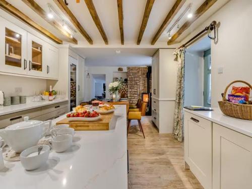 una cucina con banconi bianchi e un tavolo con frutta di The lodge spa with sauna hot tub outdoor kitchen with firepit area a Shrewsbury