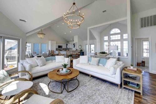 a living room with two white couches and a table at 8 Bed Oceanfront in OBX with Pool & Hot Tub in Frisco
