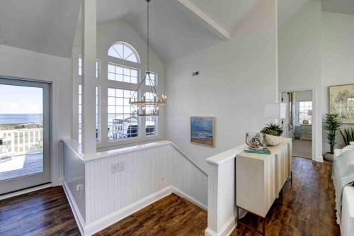 a living room with white walls and a large window at 8 Bed Oceanfront in OBX with Pool & Hot Tub in Frisco