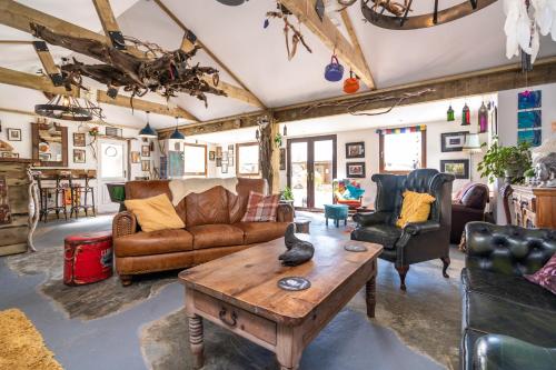 a living room with leather furniture and a table at The Hideaway Muff in Muff